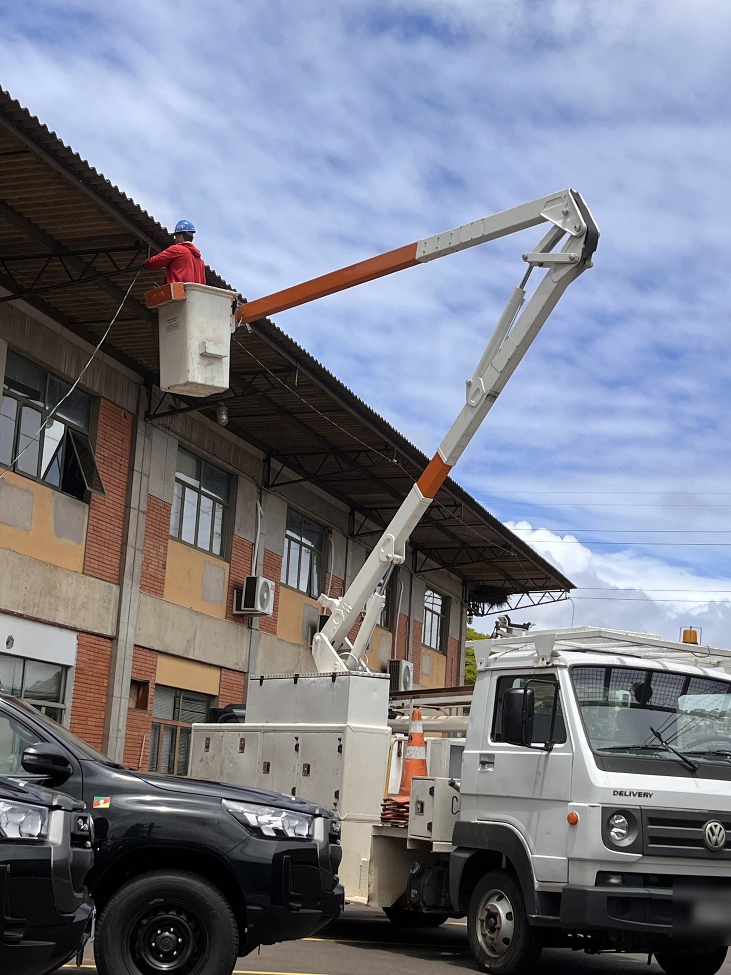 Caminhão com cesto aéreo junto a prédio